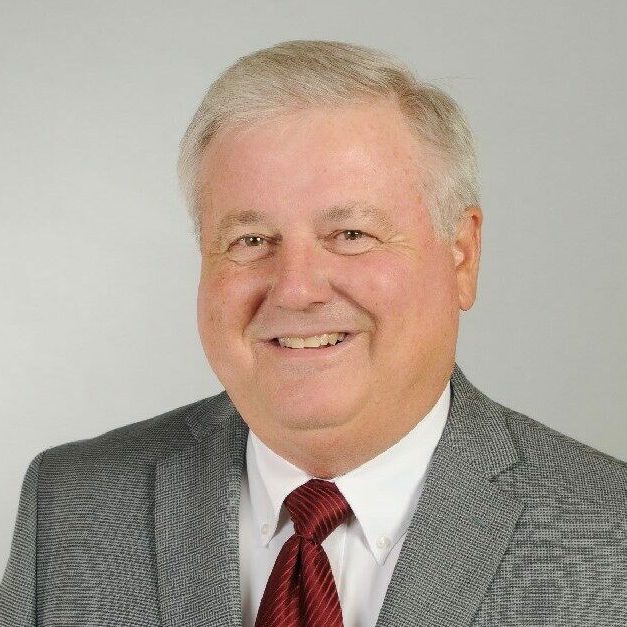 Smiling man in a gray suit.