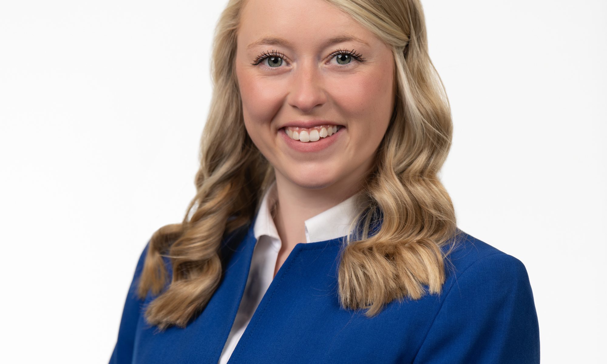 Professional headshot of a smiling woman in a blue blazer.